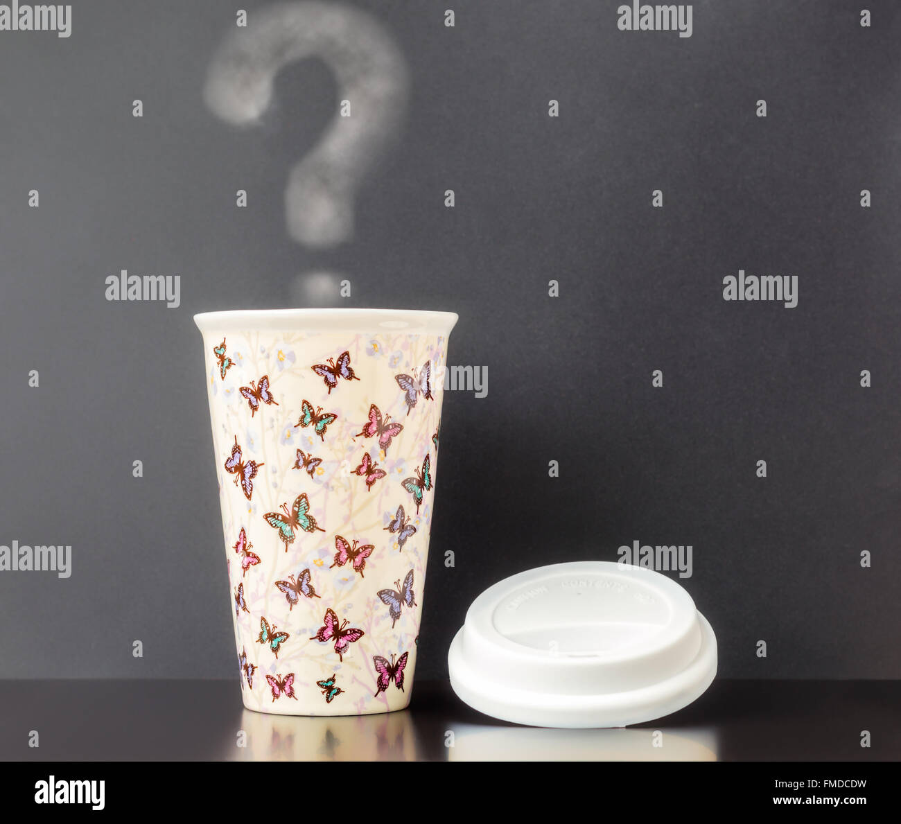 Ceramica tazza isolata con farfalla colorata pattern con sfondo grigio scuro e steamy punto interrogativo. Foto Stock