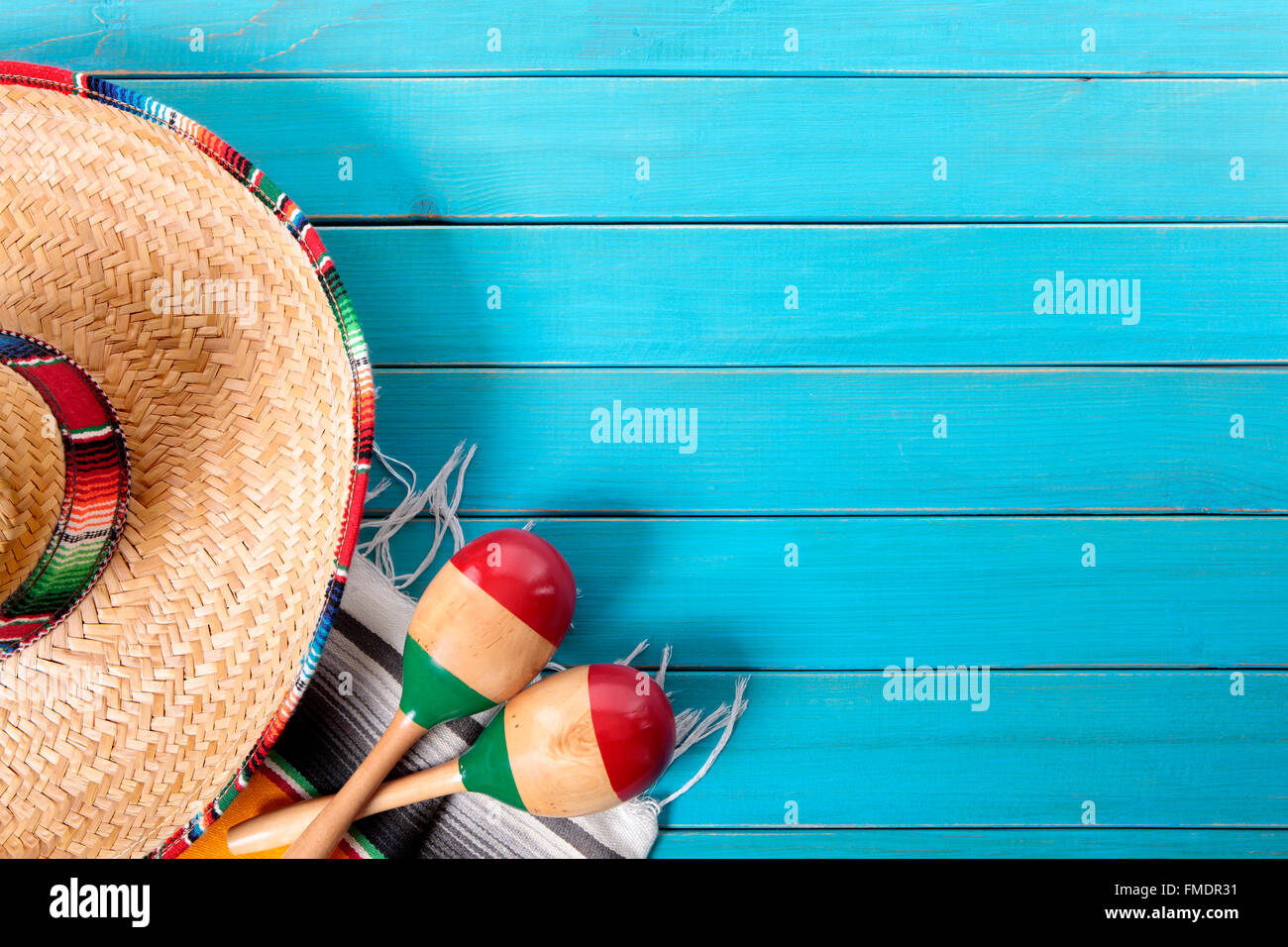 Sombrero messicano e maracas con tradizionale serape coperta prevista su un vecchio blu dipinta in legno di pino piano. Spazio per la copia. Foto Stock