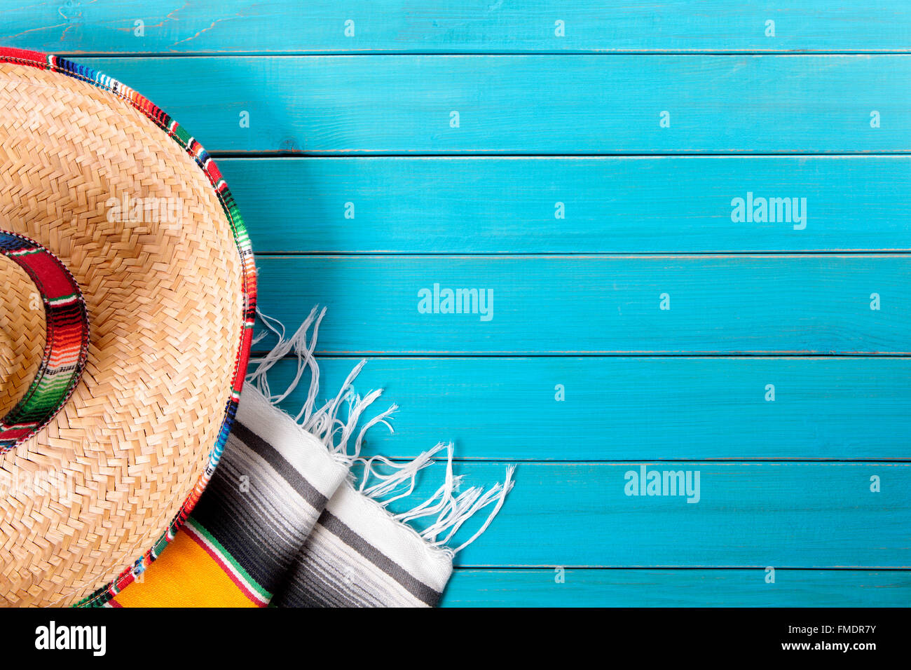 Sombrero messicano e tradizionale coperta serape prevista su un vecchio blu dipinta in legno di pino piano. Spazio per la copia. Foto Stock