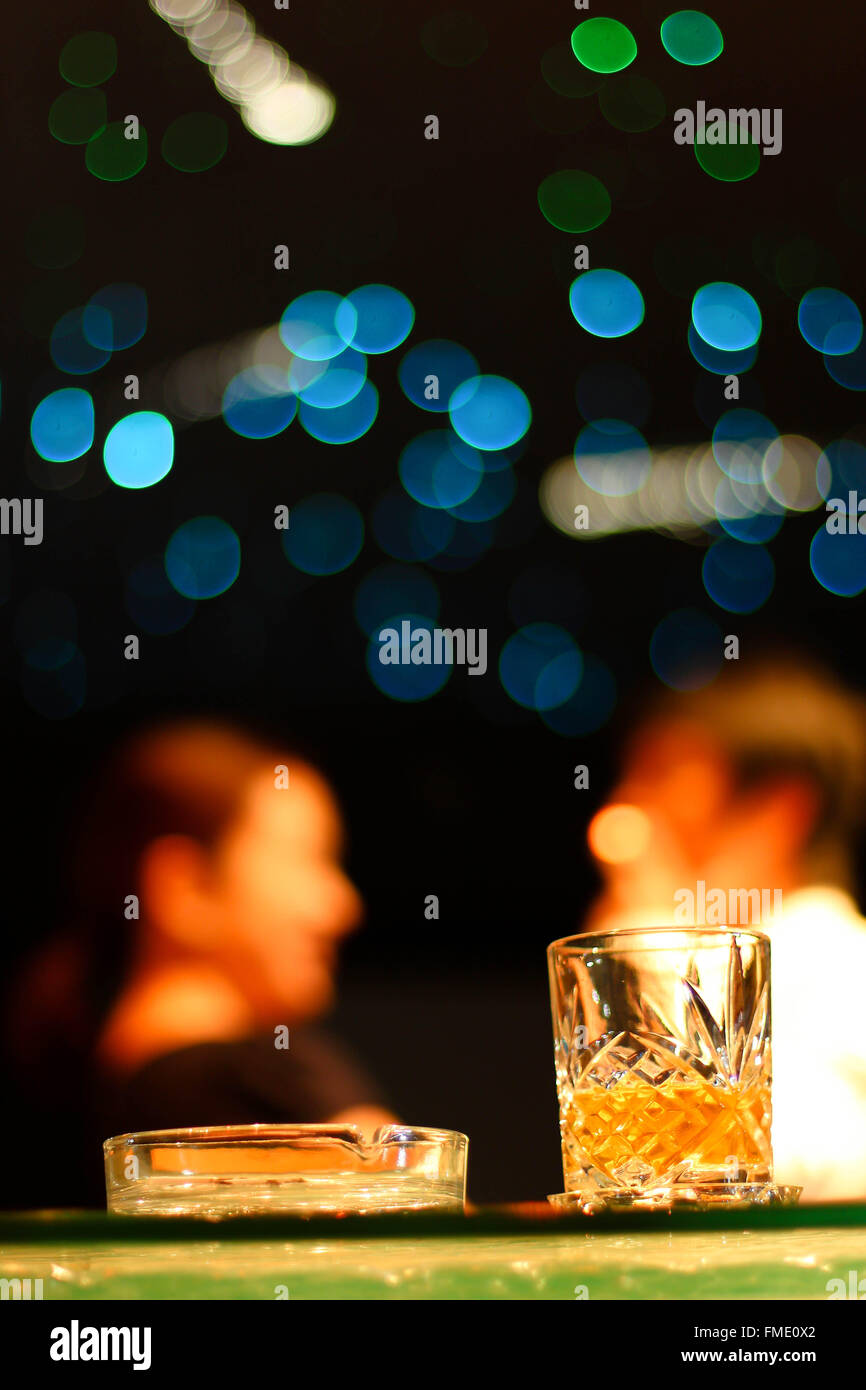 Giovane con un drink al bar dopo il lavoro Foto Stock