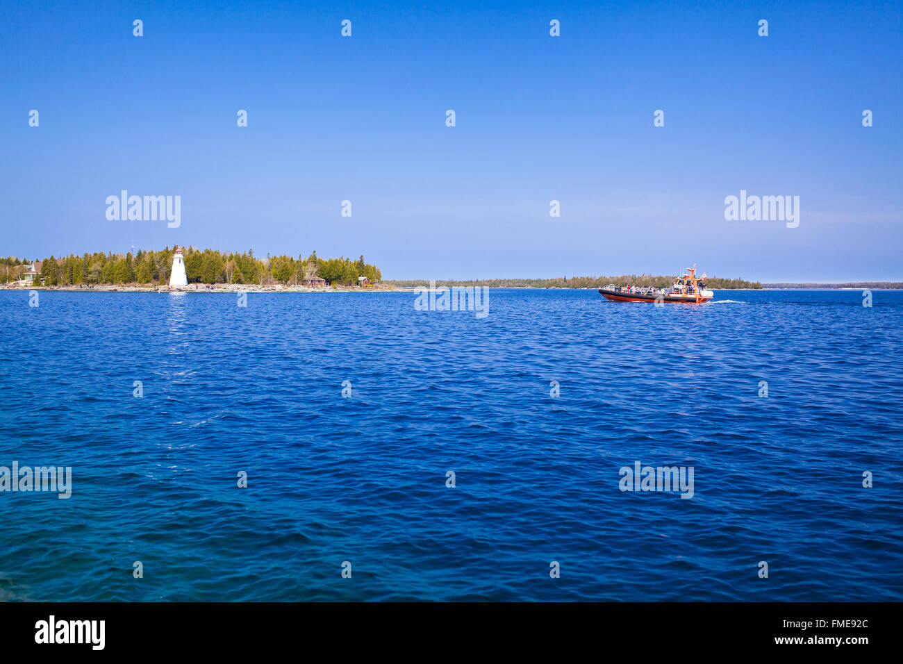 Lago, barca e una torre faro Foto Stock