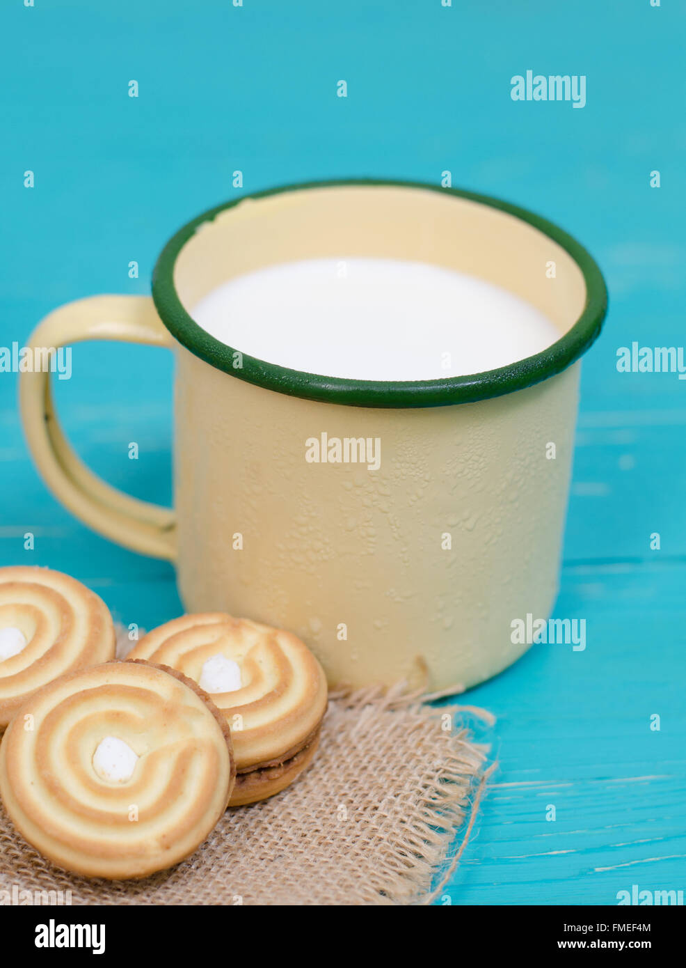 Biscotti e latte sul blu sullo sfondo di legno Foto Stock