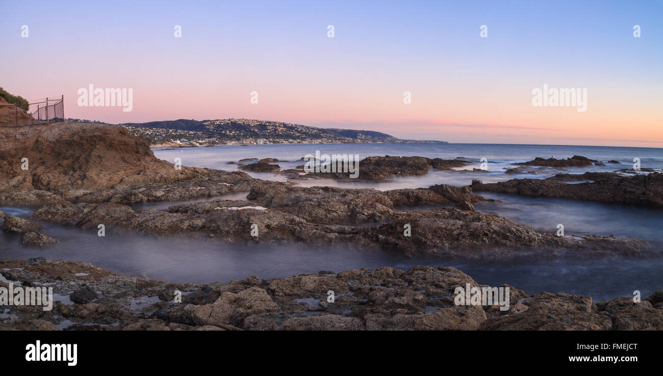 Una lunga esposizione del tramonto su rocce, dando una nebbia simile effetto sull'oceano in Laguna Beach, California, Stati Uniti Foto Stock