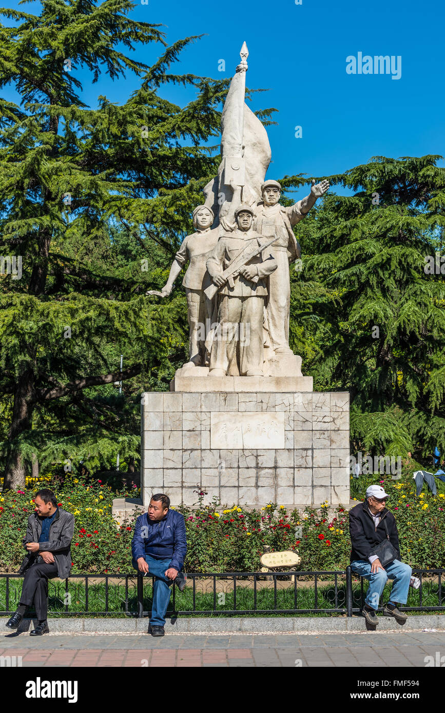 Gli uomini cinesi rilassante nella parte anteriore della statua rivoluzionario in Dongdan Park di DongCheng District, Pechino Foto Stock