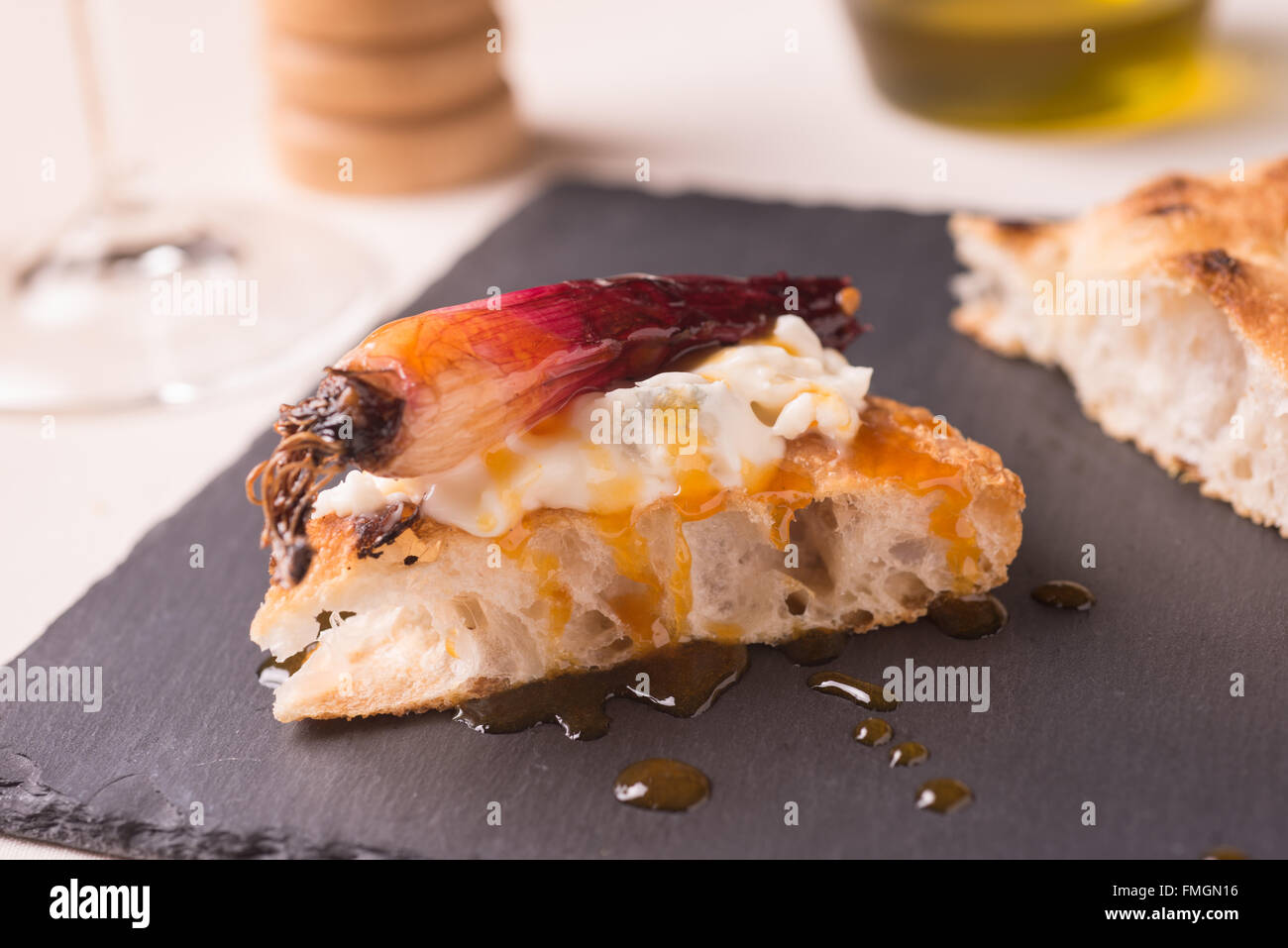 Un trancio di pizza gourmet con gorgonzola e cipolla rossa stufati su winegar balsamico e sciroppo di arancia Foto Stock