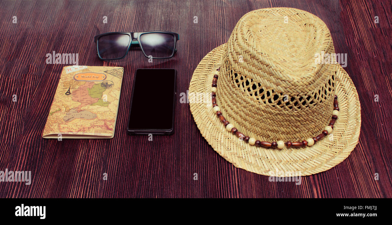 Accessori da viaggio telefono, cappello, occhiali da sole, passaporto su sfondo di legno Foto Stock