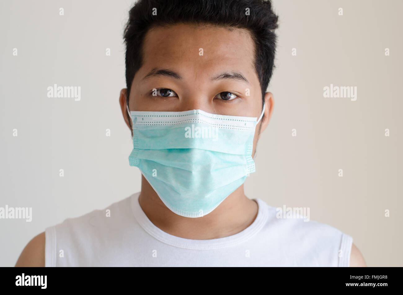 Uomo asiatico che indossa una maschera per il viso Foto Stock