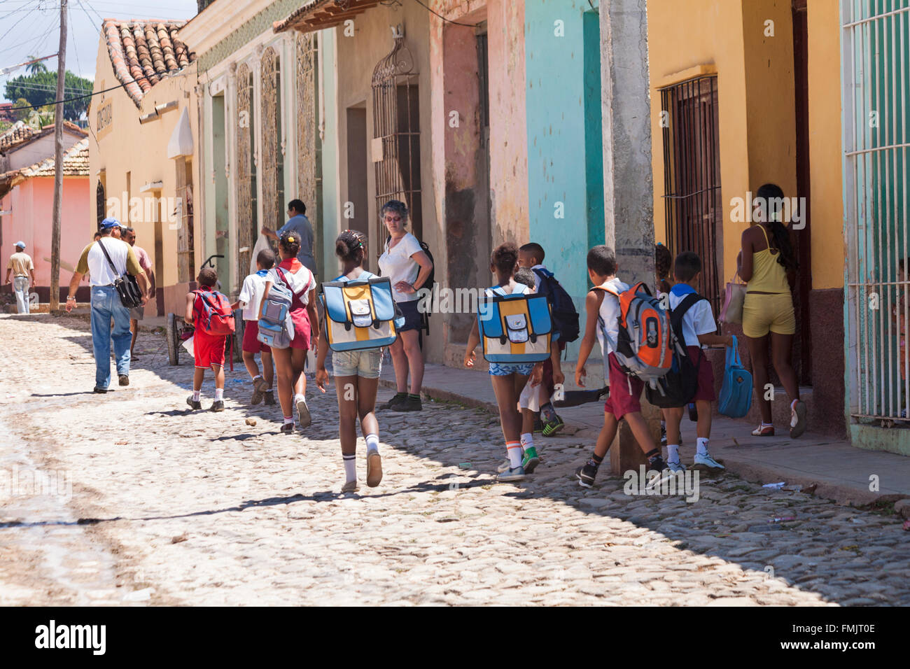 Vita quotidiana scena di strada con la scuola i bambini camminando per strada di ciottoli a Trinidad, Cuba nel Marzo Foto Stock