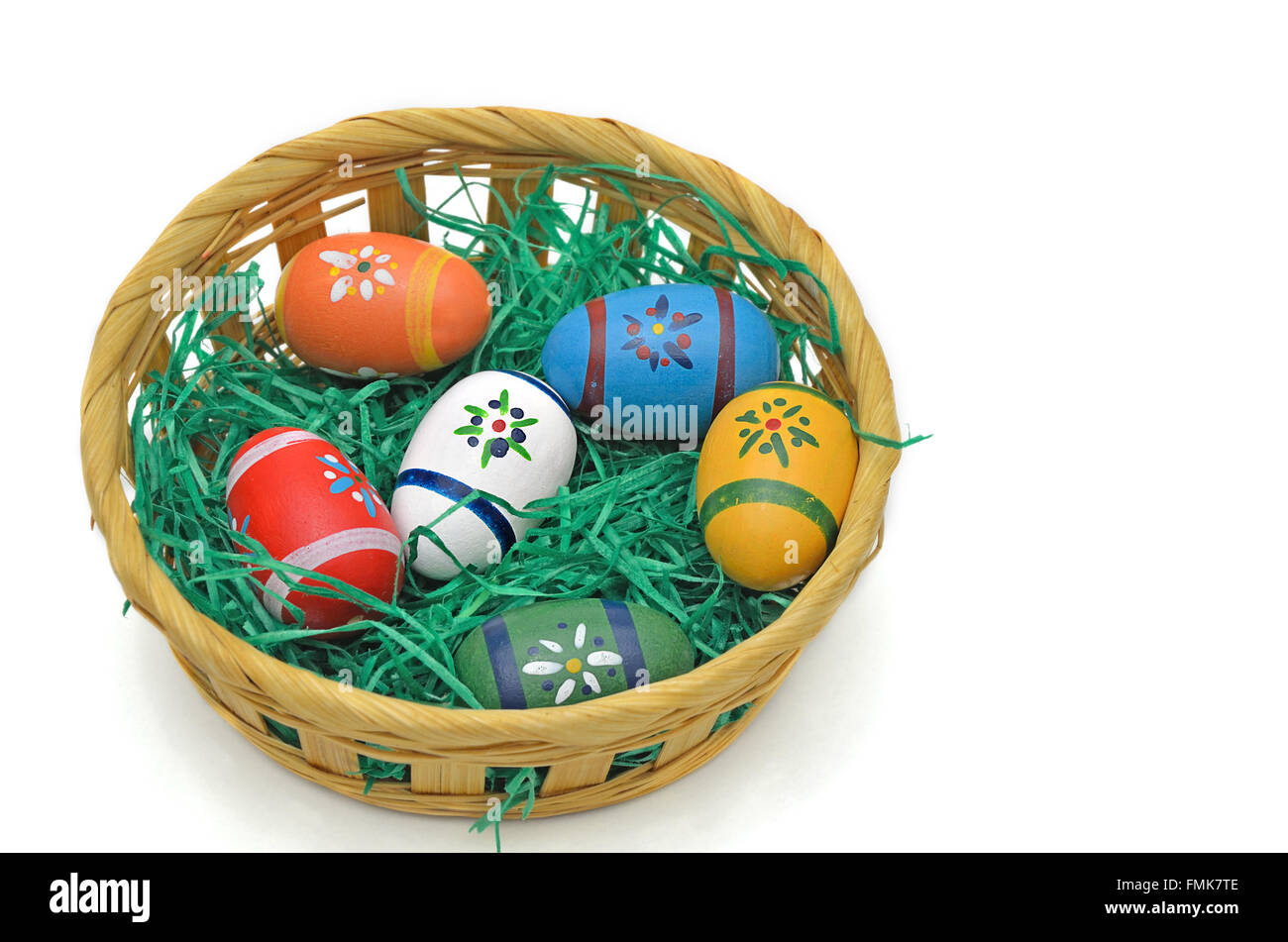 Colorate le uova di Pasqua in un cestello, vicino, isolati su sfondo bianco Foto Stock