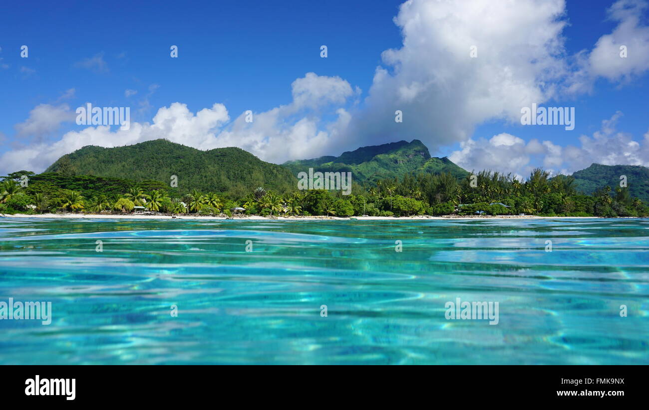 Il paesaggio costiero di Huahine isola, visto dalla superficie dell'acqua nella laguna, oceano pacifico, Polinesia Francese Foto Stock