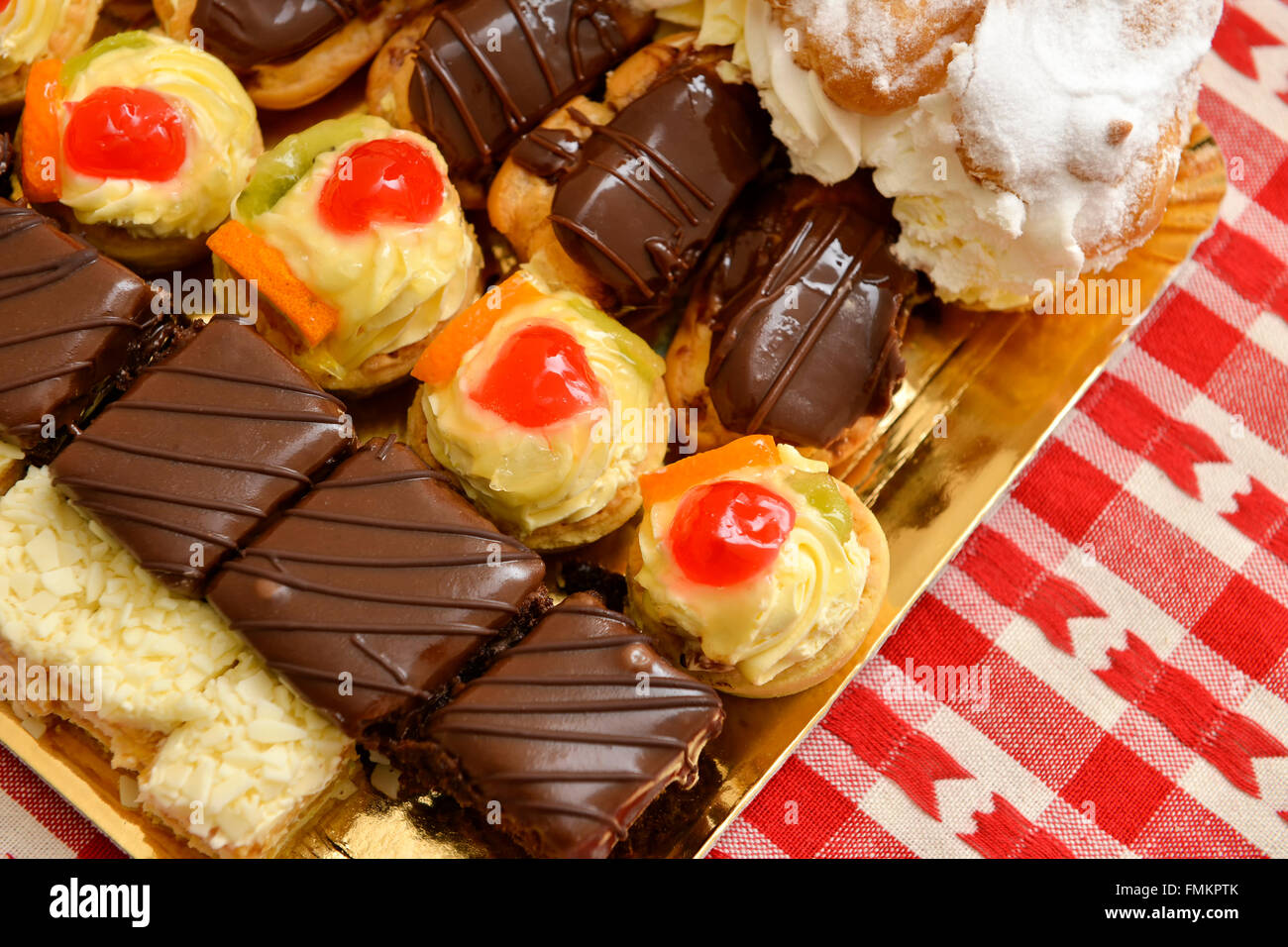 Eclair e un sacco di torte su un tavolo Foto Stock