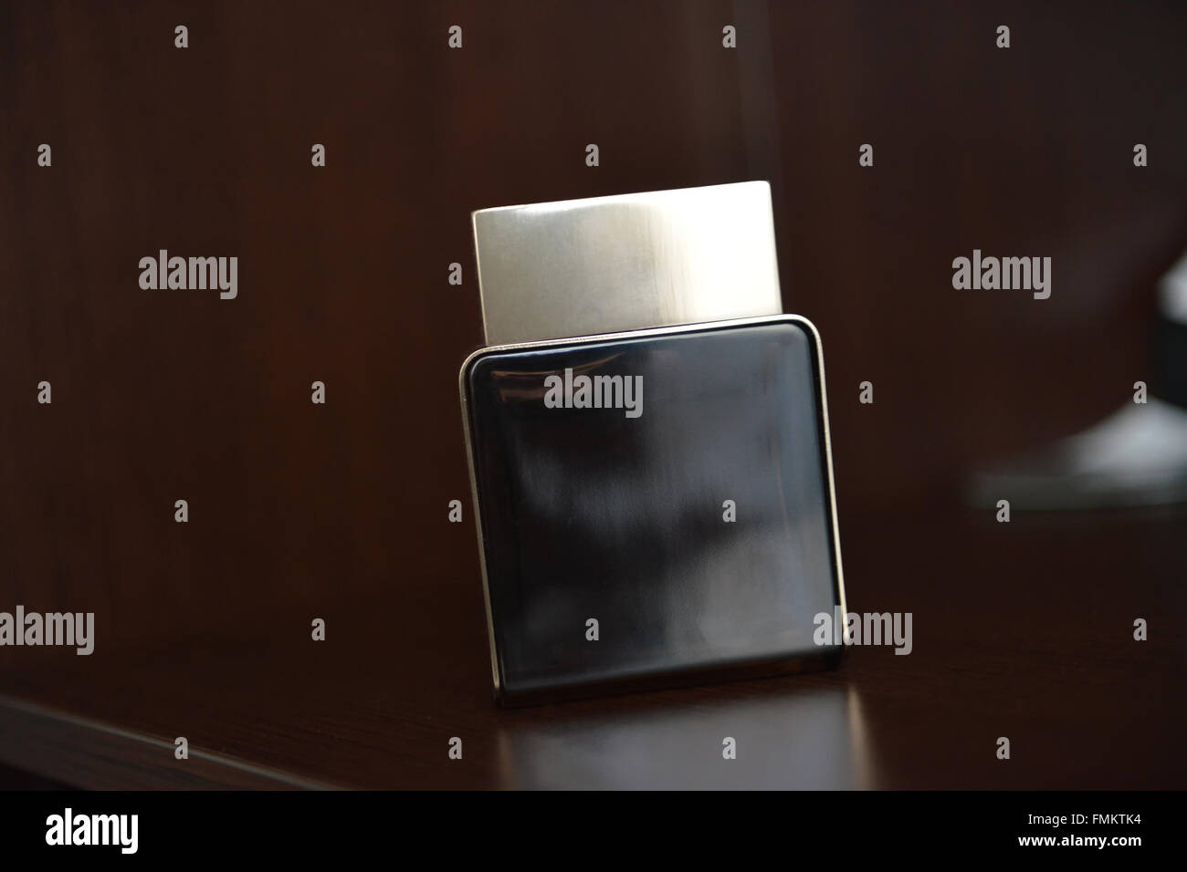 Profumo maschile seduto sul ripiano di luce naturale Foto Stock