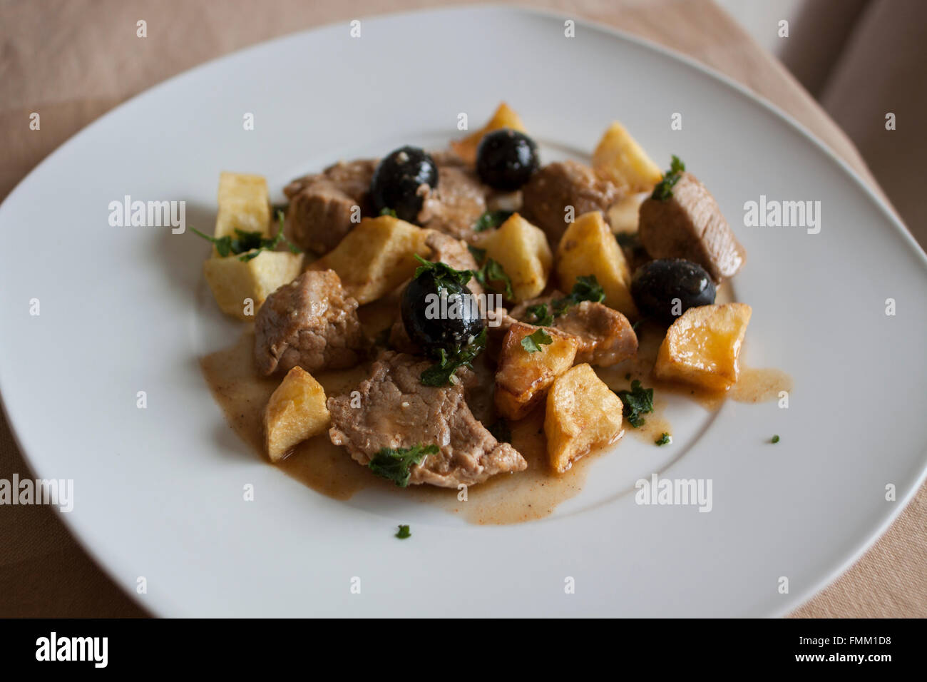 La carne di maiale con patate e olive Foto Stock