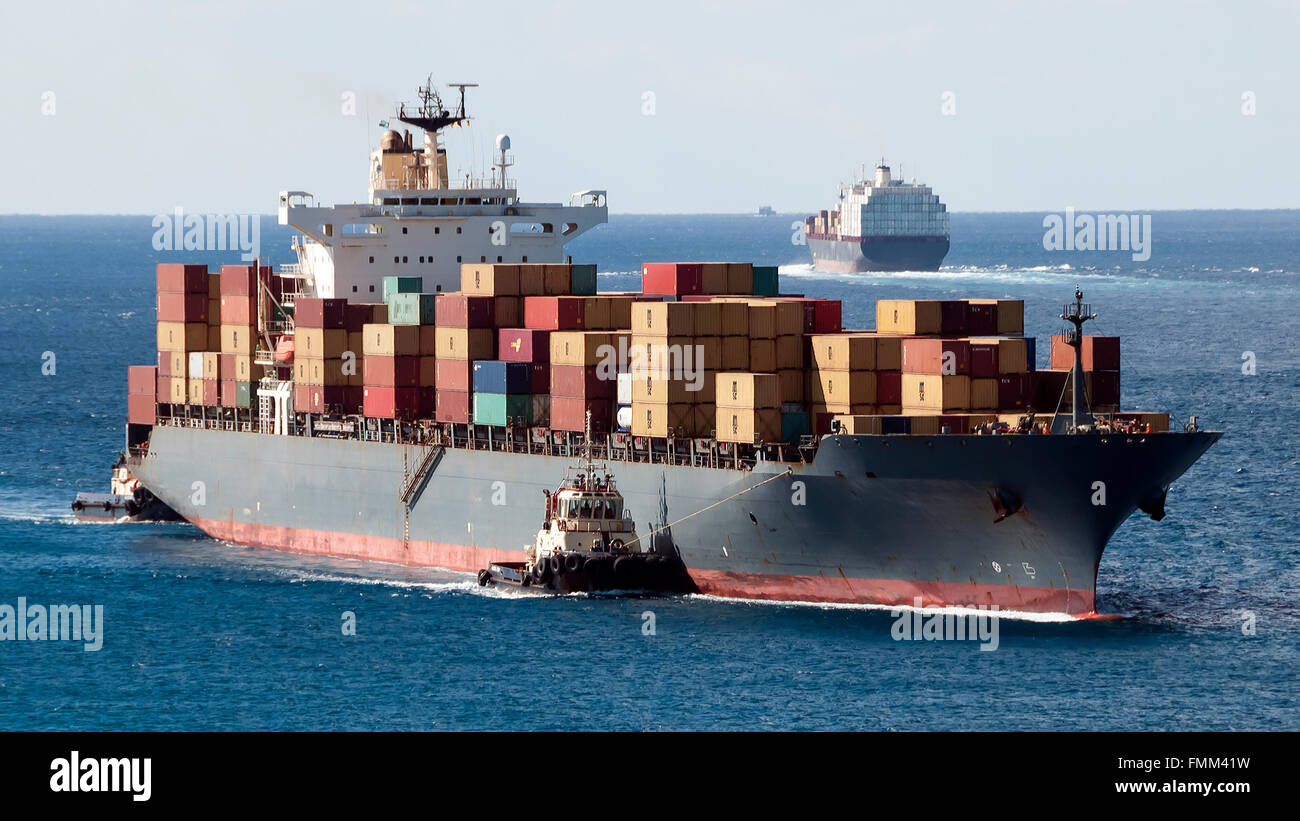Porto di Freeport Grand Bahama Island con molti contenitori di navi in arrivo e in partenza dal porto riempita con carico e rimorchiatore Foto Stock