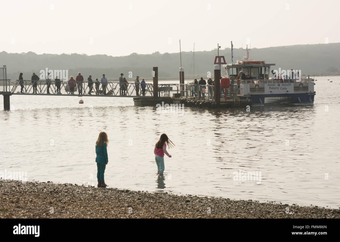 Traghetto per Mudeford a Hengistbury Head, Christchurch, Dorset, Regno Unito. Persone che accodano sul jetty a bordo, marzo. Foto Stock