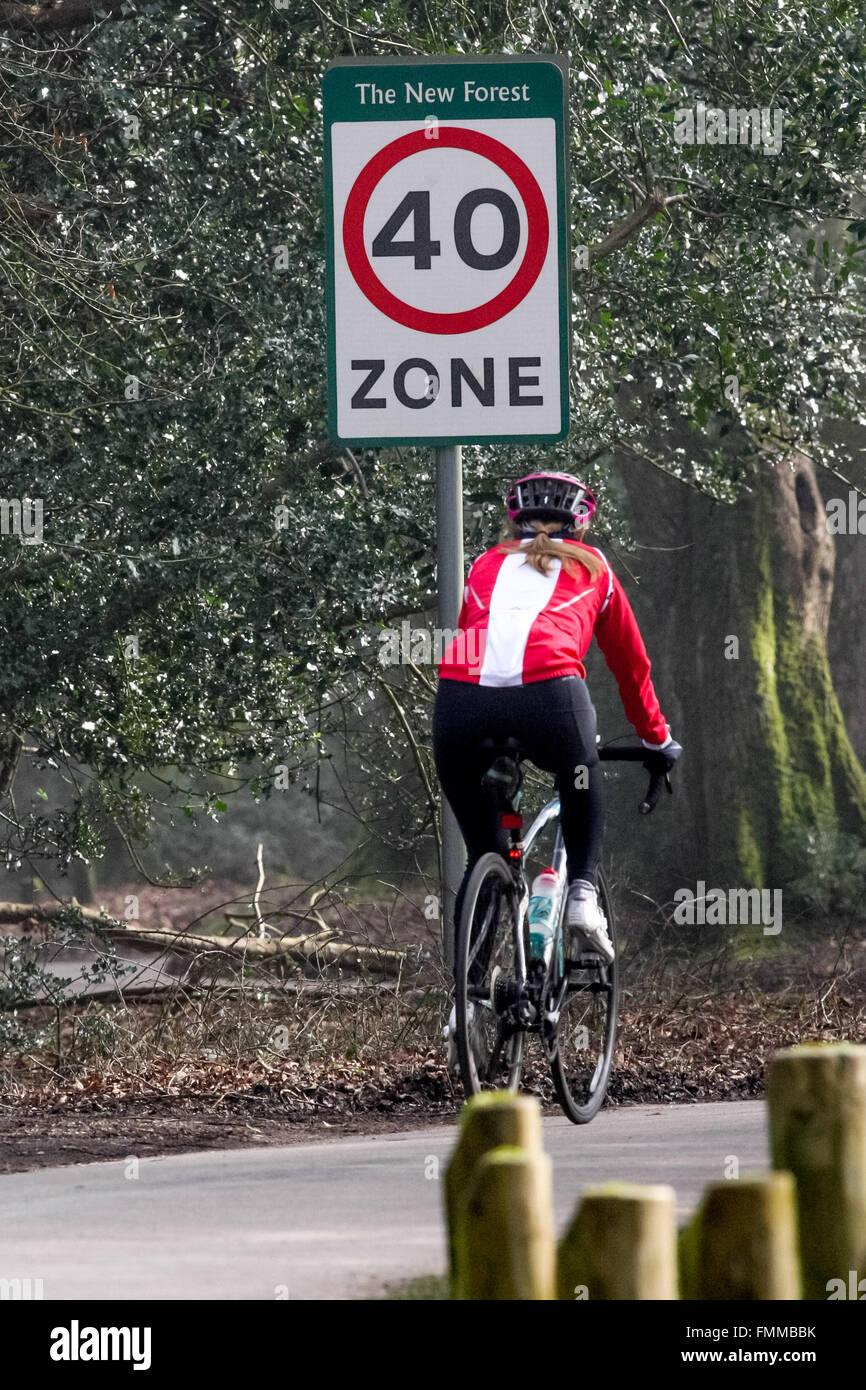 Un ciclista che passa a 40 miglia all'ora zona di velocità segno nella nuova foresta Hampshire Foto Stock