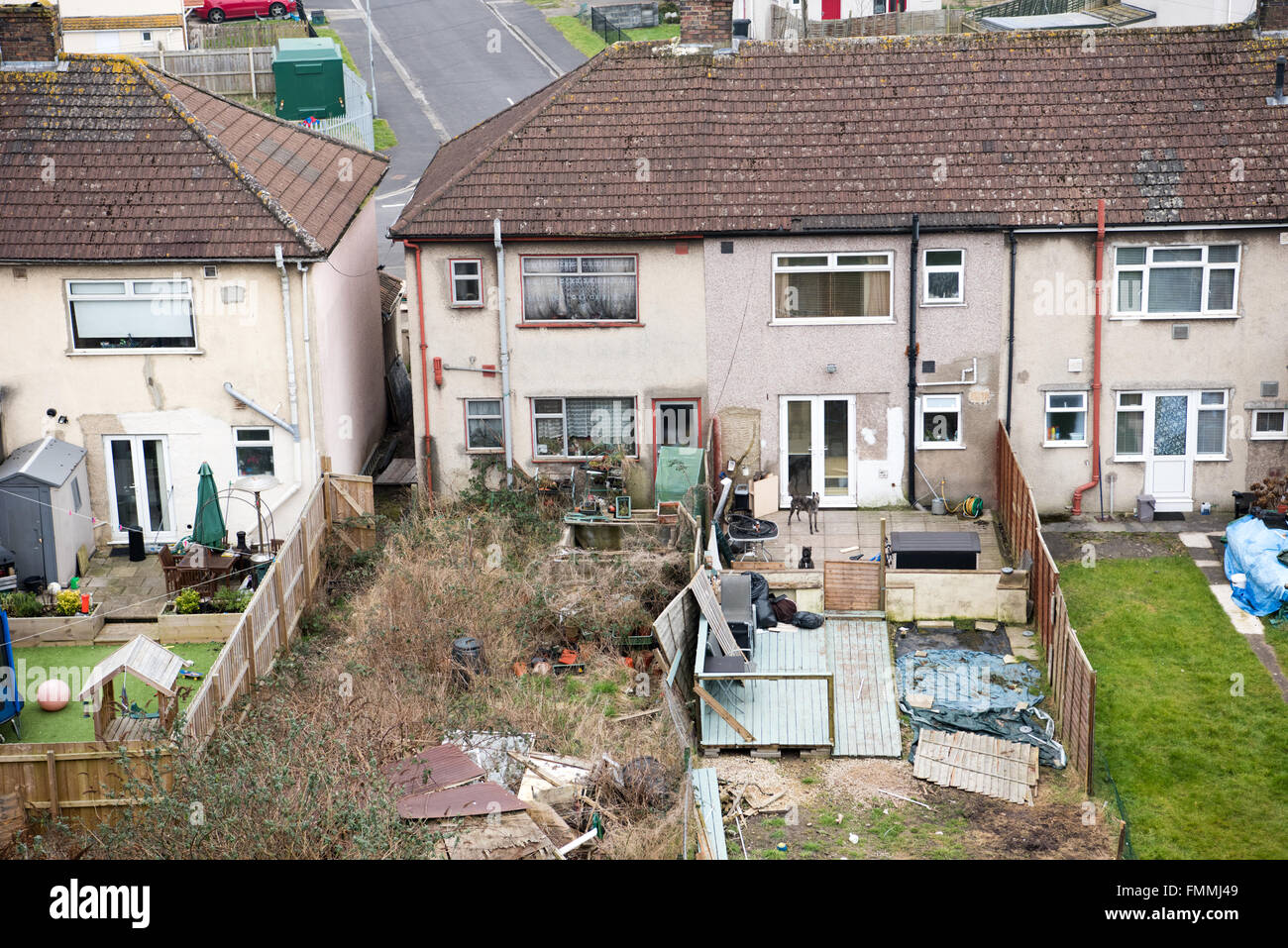 Ariel vista di un vicini dall'inferno delle baraccopoli ex 1950 casa consiglio con ratto-infestato giardino, finestre sporche e cumuli di rifiuti in giardino Foto Stock