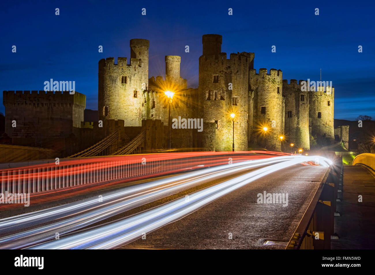Conwy Castle e Roadbridge con percorsi di traffico di notte, Conwy, Galles del Nord, Regno Unito Foto Stock