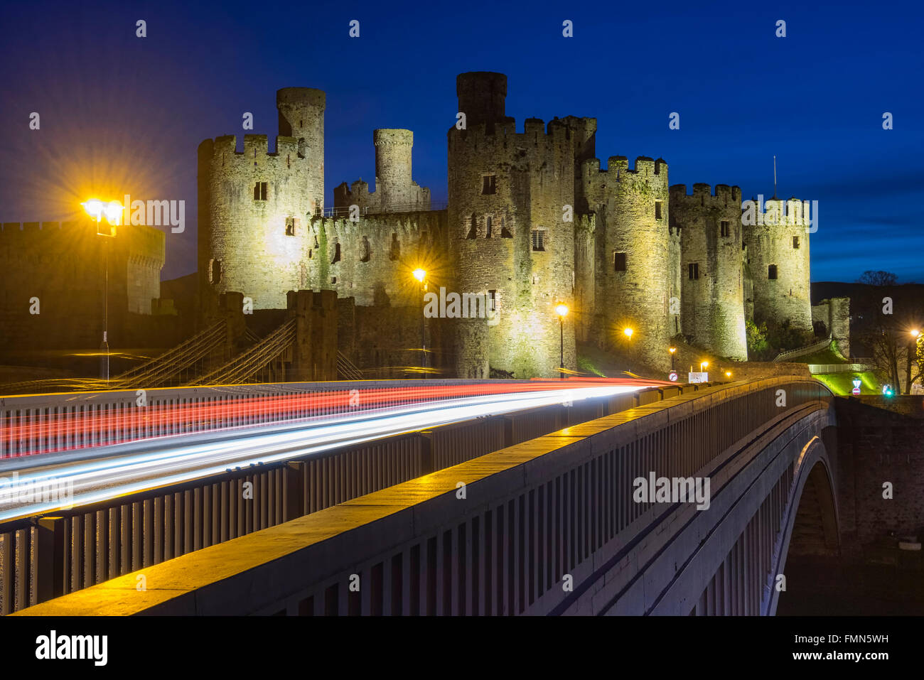 Conwy Castle e Roadbridge con percorsi di traffico di notte, Conwy, Galles del Nord, Regno Unito Foto Stock