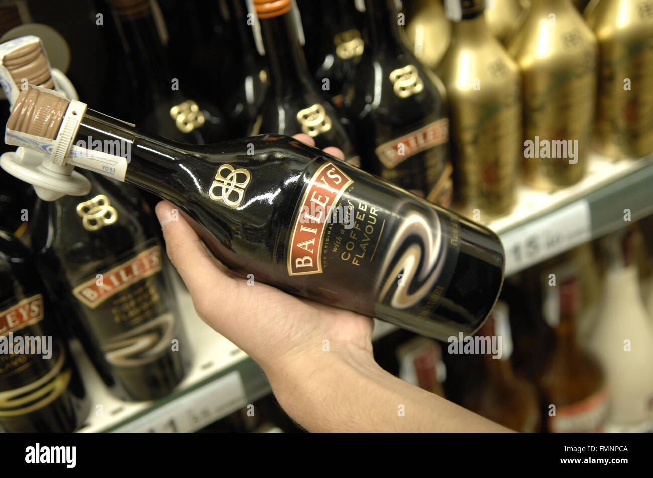 Il Baileys bottiglia essendo mantenuto a Carrefour - Malaga, Spagna Foto Stock