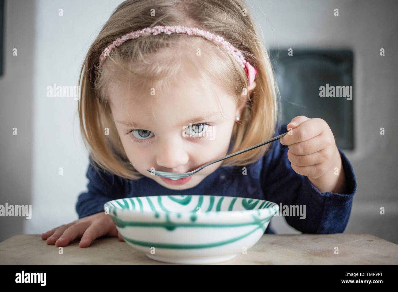 Bambina mangiare cereali da una ciotola, Alta Baviera, Germania Foto Stock