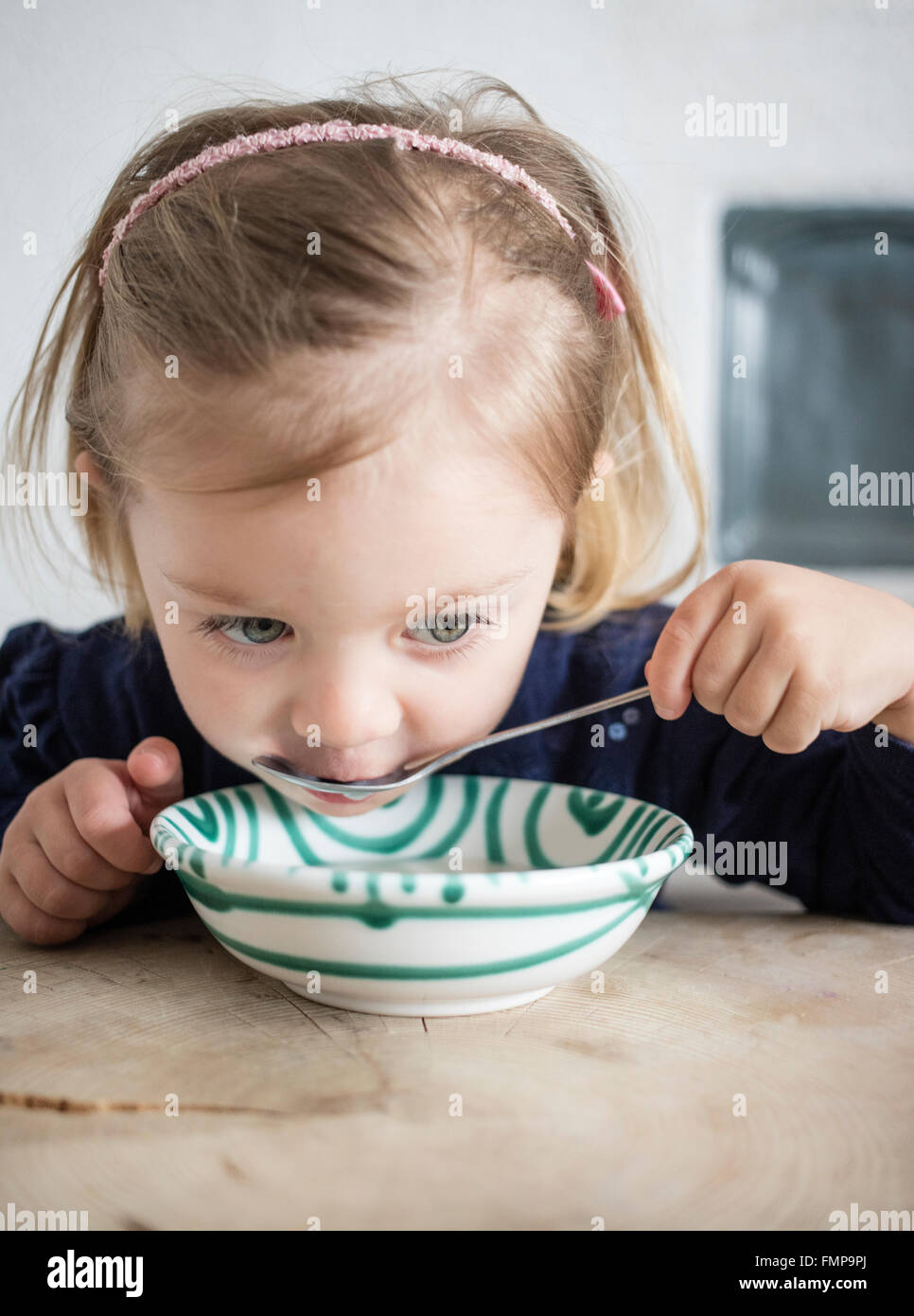 Bambina mangiare cereali da una ciotola, Alta Baviera, Germania Foto Stock