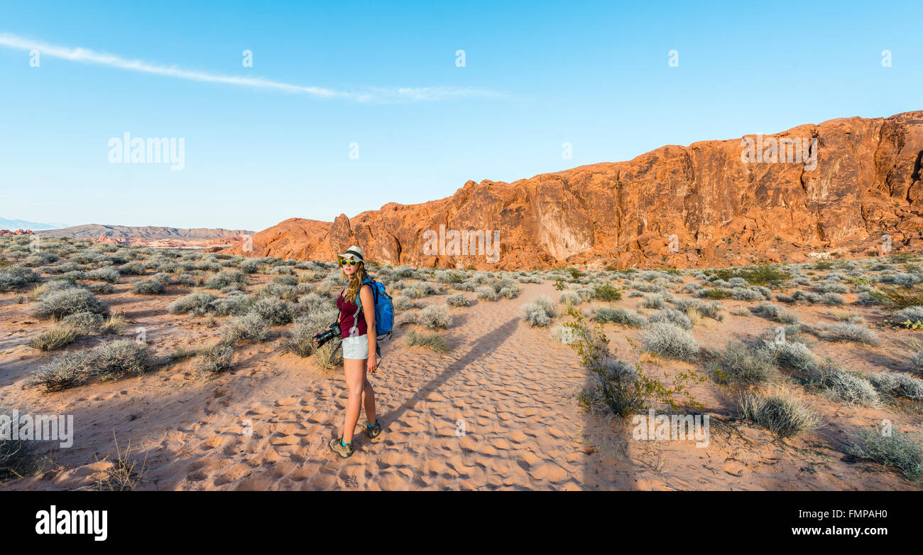 Donna escursionismo attraverso il deserto, la Valle del Fuoco del parco statale, Nevada, STATI UNITI D'AMERICA Foto Stock