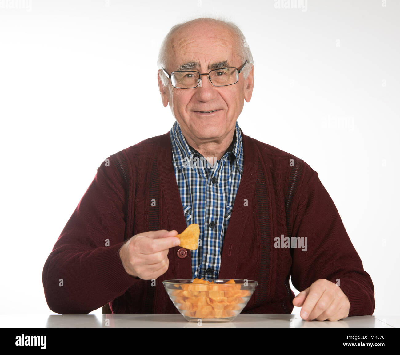 Il vecchio uomo senior mangiare patatine Foto Stock