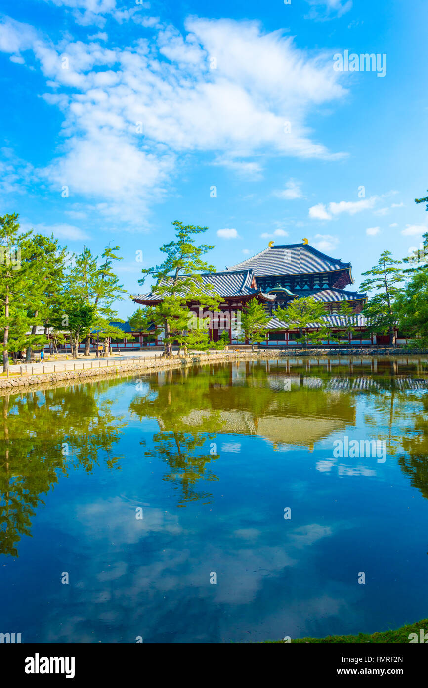 Passaggio pedonale e calma reflectiion stagno di rosso anteriore porta di ingresso a Daibutsuden visto in distanza sulla bella e soleggiata sk blu Foto Stock