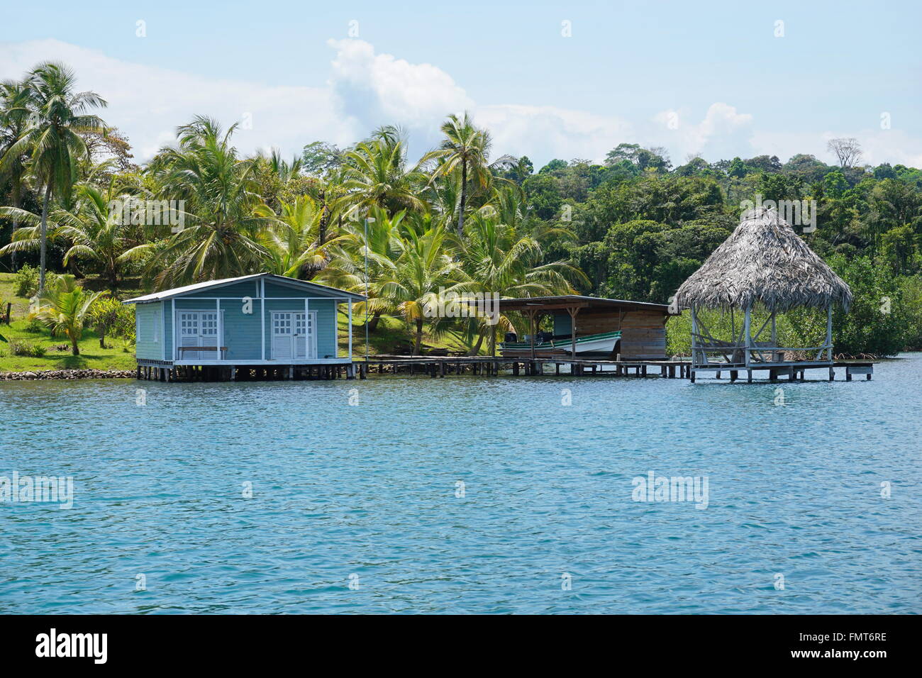 Costa Tropicale con piccola casa e capanna con il tetto di paglia sopra l'acqua in Bocas del Toro, Costa Caraibica di Panama, America Centrale Foto Stock