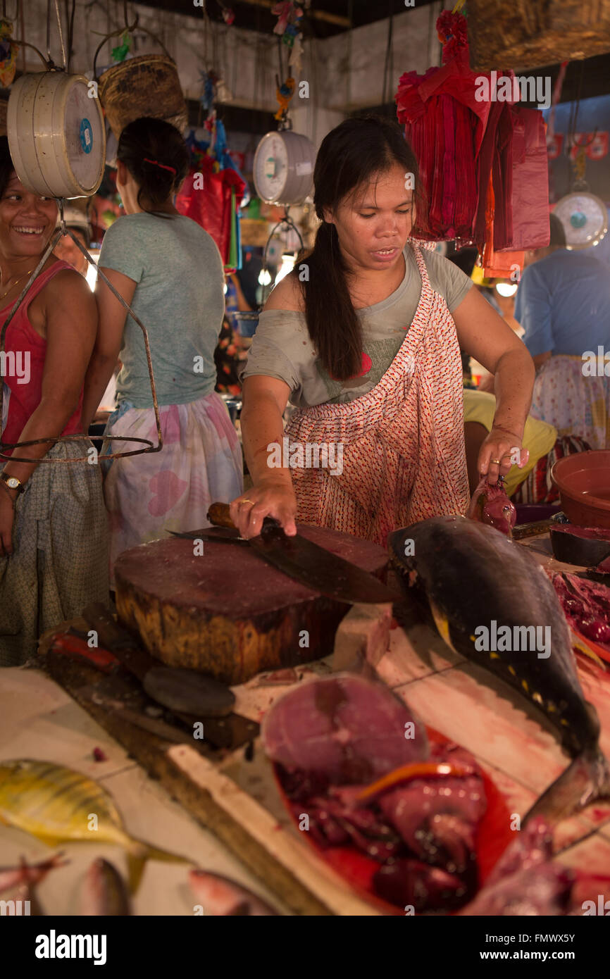 Una donna si prepara a un budello di tonno fresco, nel mercato Talisay,Cebu City, Filippine Foto Stock