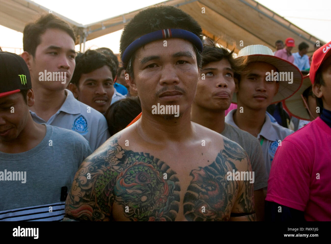 Un Muay Thai boxer di tatuaggi sono mostrati prima di lui entra un pugilato ring per un incontro di boxe in un festival Kampong Cham, Cambogia. Foto Stock