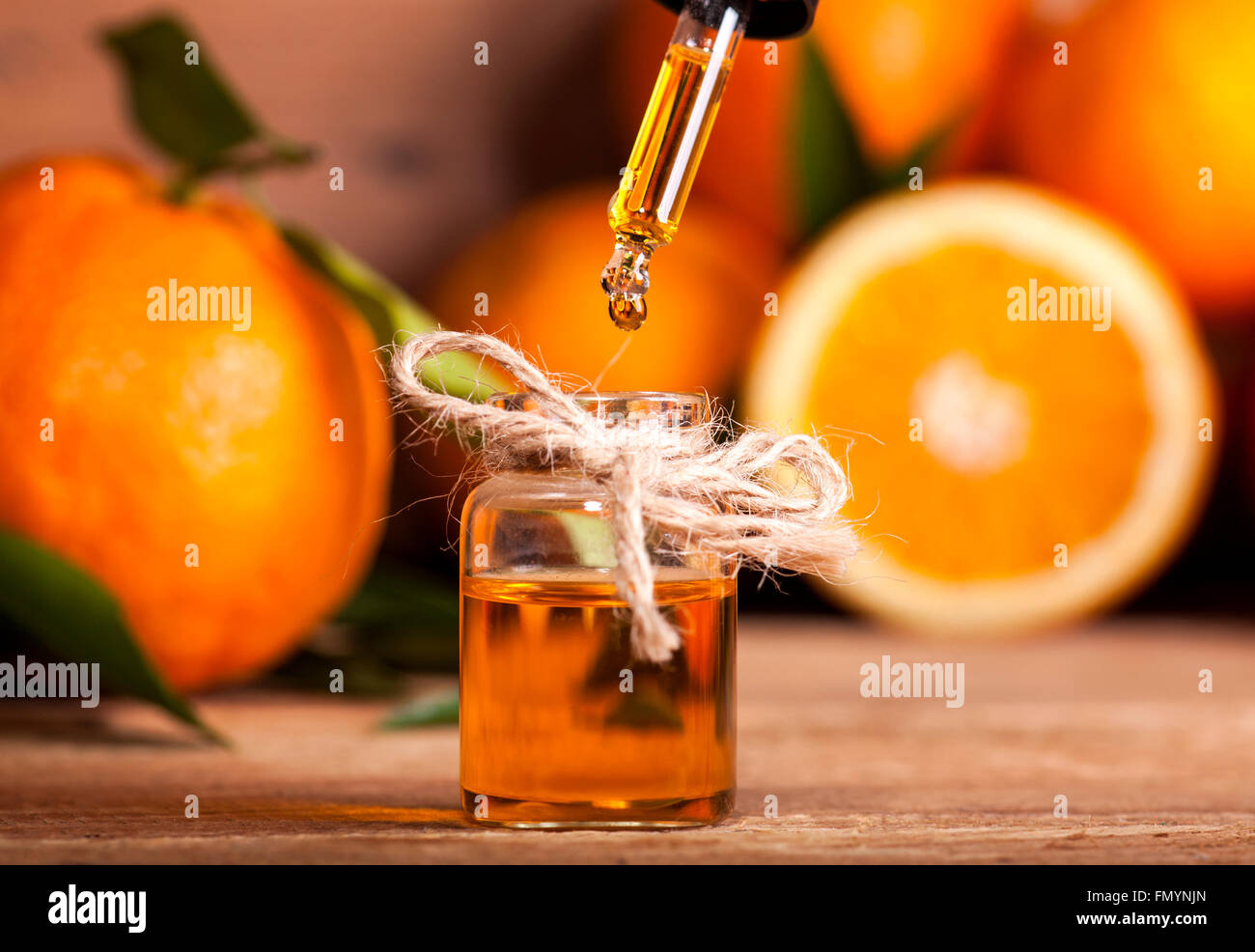 Bottiglia di olio essenziale di arance su sfondo di legno - medicina alternativa Foto Stock
