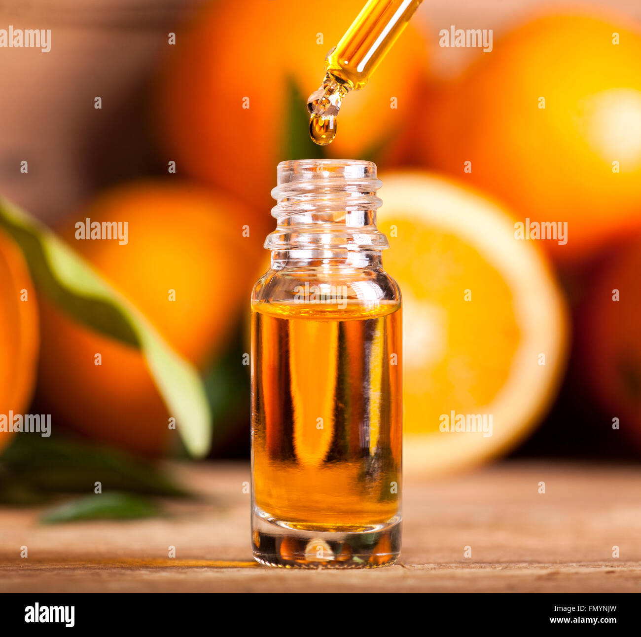 Bottiglia di olio essenziale di arance su sfondo di legno - medicina alternativa Foto Stock