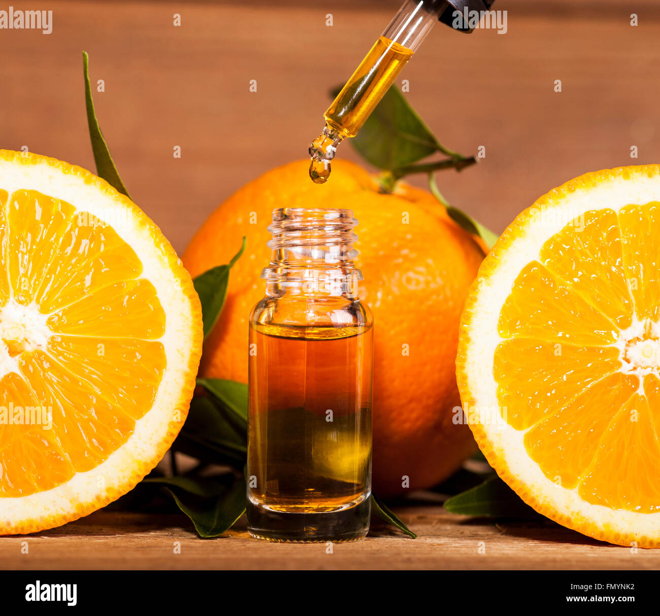 Bottiglia di olio essenziale di arance su sfondo di legno - medicina alternativa Foto Stock