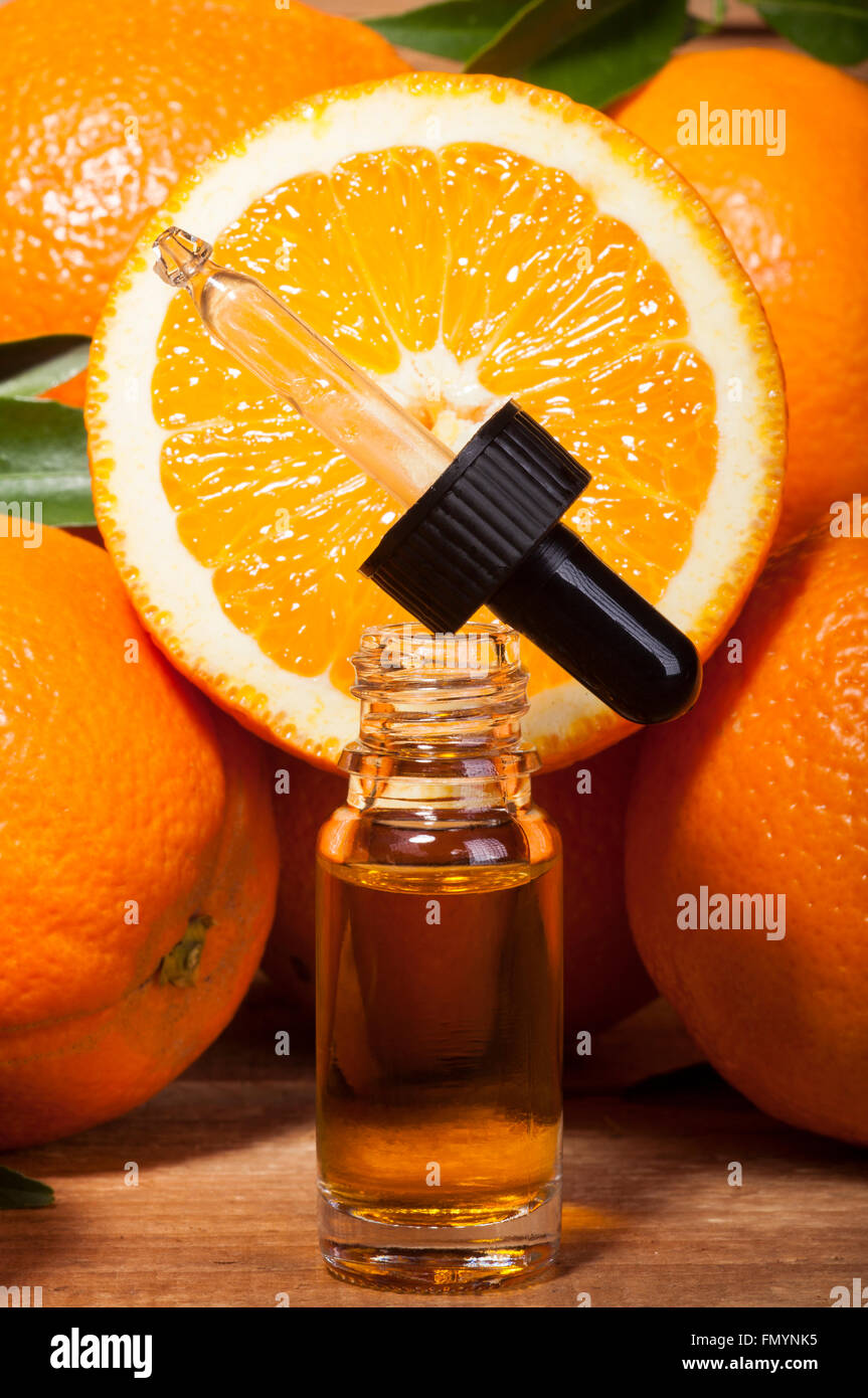 Bottiglia di olio essenziale di arance su sfondo di legno - medicina alternativa Foto Stock