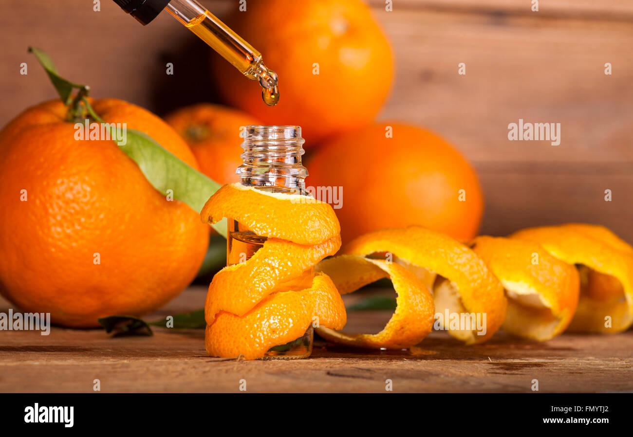 Bottiglia di olio essenziale di arance su sfondo di legno - medicina alternativa Foto Stock