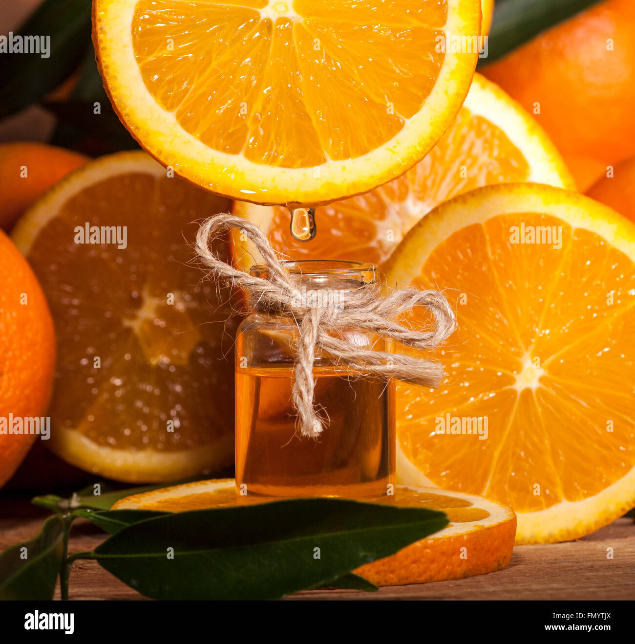 Bottiglia di olio essenziale di arance su sfondo di legno - medicina alternativa Foto Stock