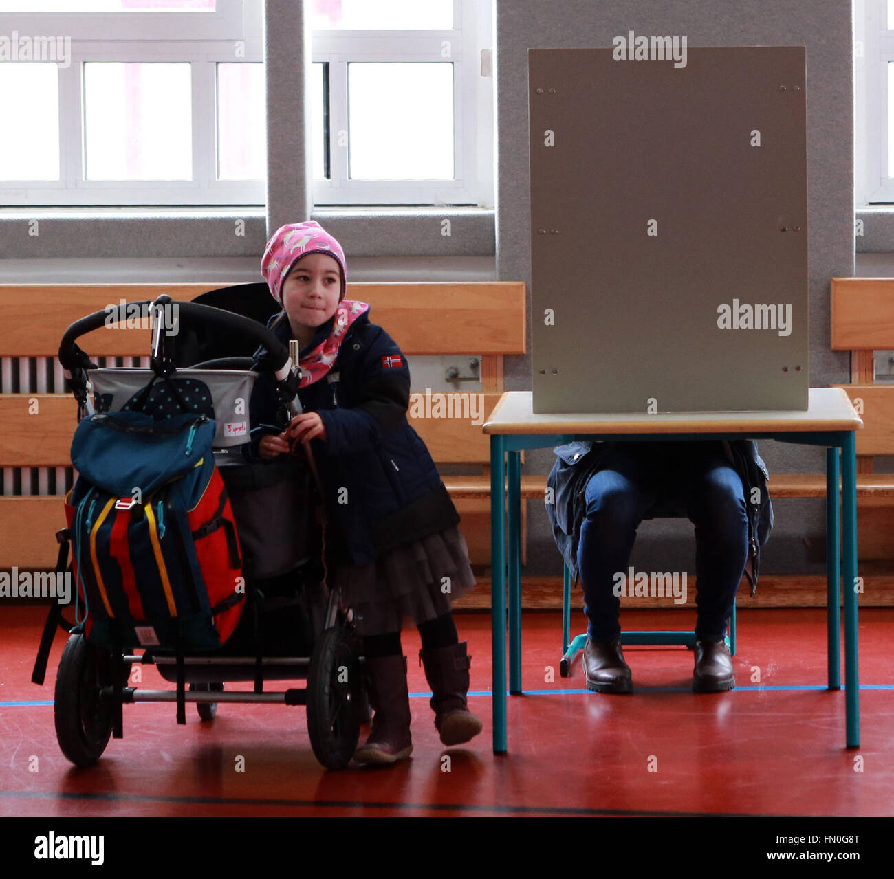 (160313) -- MAINZ, 13 marzo 2016 (Xinhua) -- Daniela Moerscher riempie il ballottaggio mentre sua figlia attende al suo lato in corrispondenza di una stazione di polling in Mainz, Germania, 13 marzo 2016. Alle elezioni statali in tre stati tedeschi, Renania-Palatinato, Sassonia Anhalt e Baden-Wuerttemberg, si terrà domenica, che è una prova cruciale-case per il Cancelliere tedesco e la presidentessa del tedesco cristiano-democratici (CDU) Angela Merkel, che è venuto sotto la crescente pressione sopra la sua politica in materia di immigrazione verso i migranti e i rifugiati. La Germania anti-migrazione delle parti, l'alternativa per la Germania ha solidi numeri di polling Foto Stock