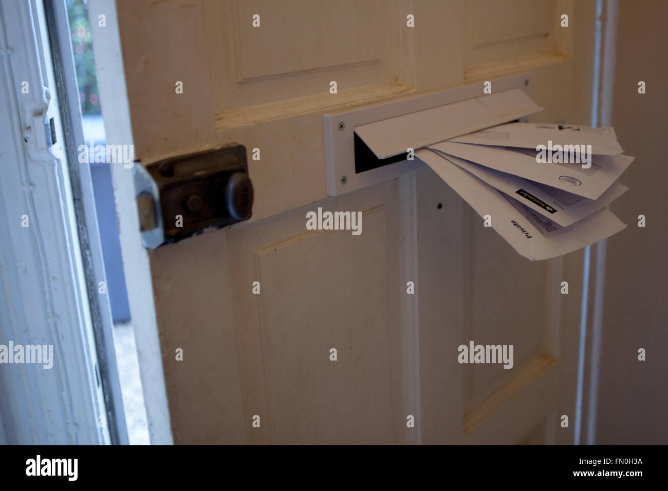 Lettere e fatture farcite attraverso una buca delle lettere Foto Stock