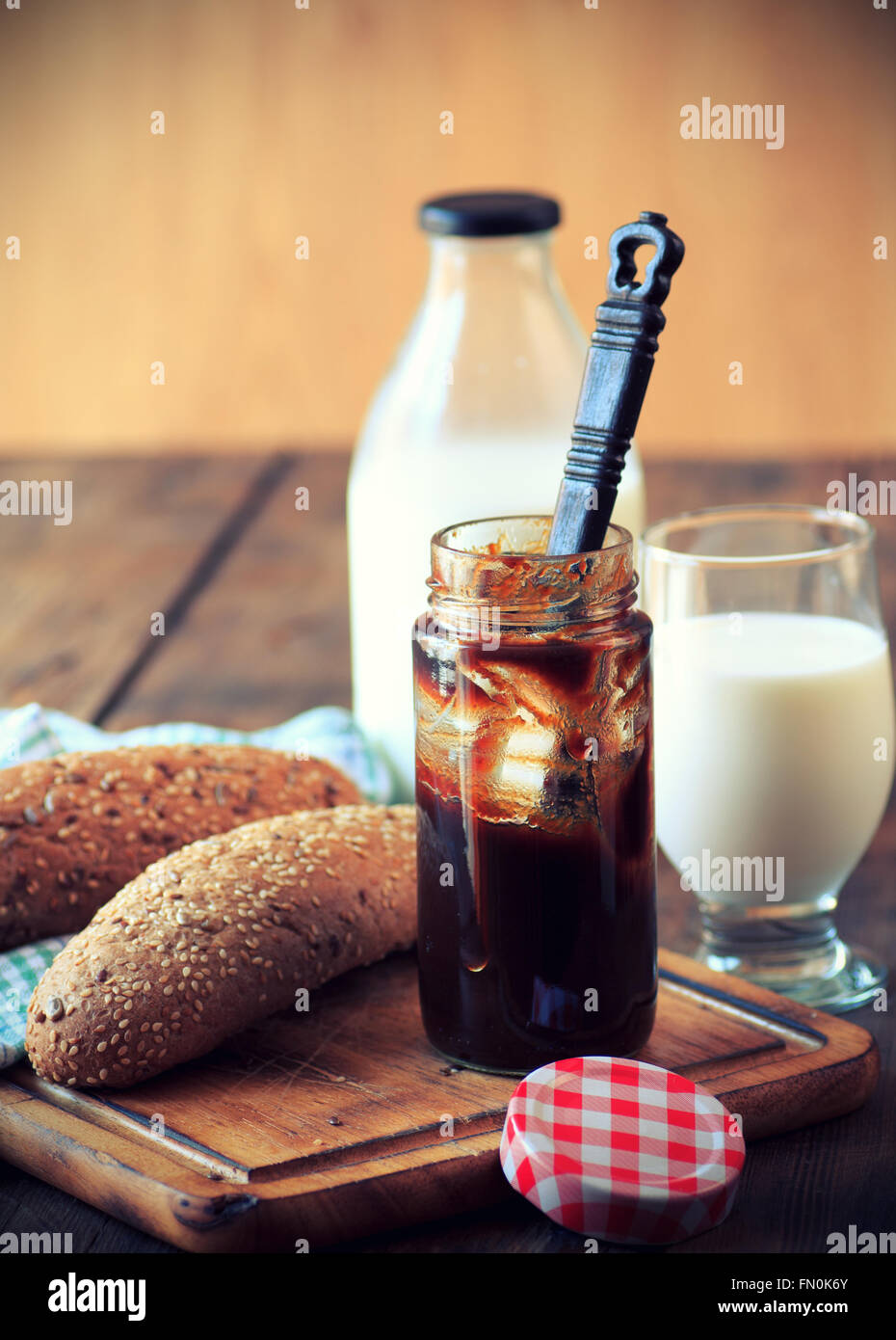 La prima colazione con latte, grano intero panini, burro e marmellata Foto Stock