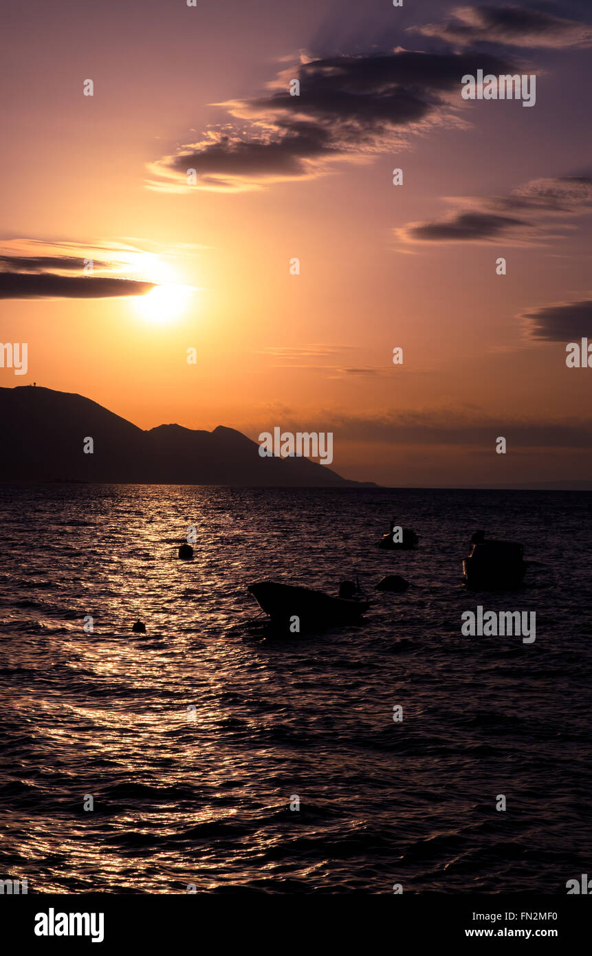 Silhouette di barche sul mare al tramonto rosa Foto Stock