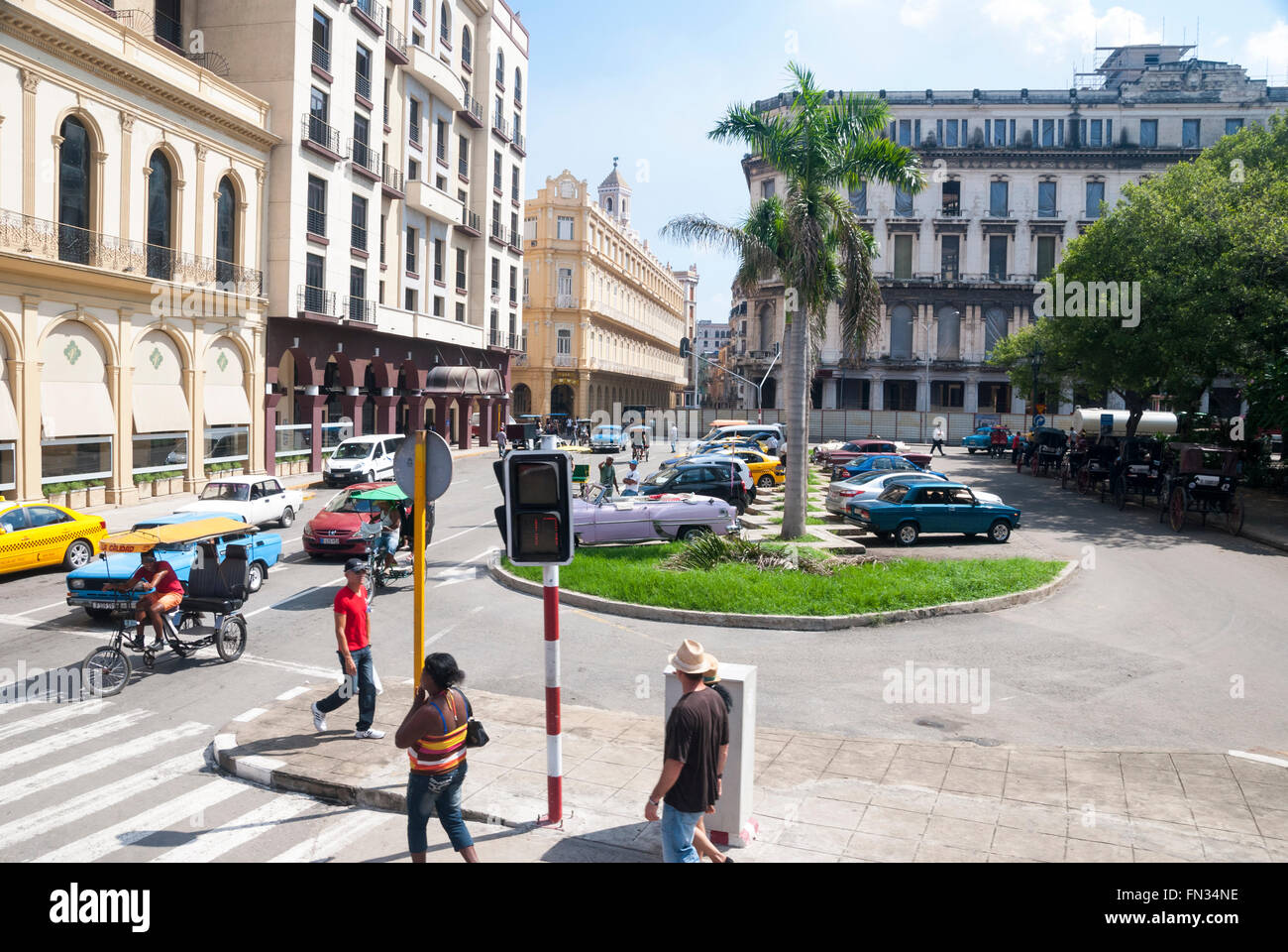 Turisti e pedoni cubani che attraversano una strada trafficata sul Paseo del Prado (Paseo de Marti) nella parte centrale di l'Avana Cuba Foto Stock