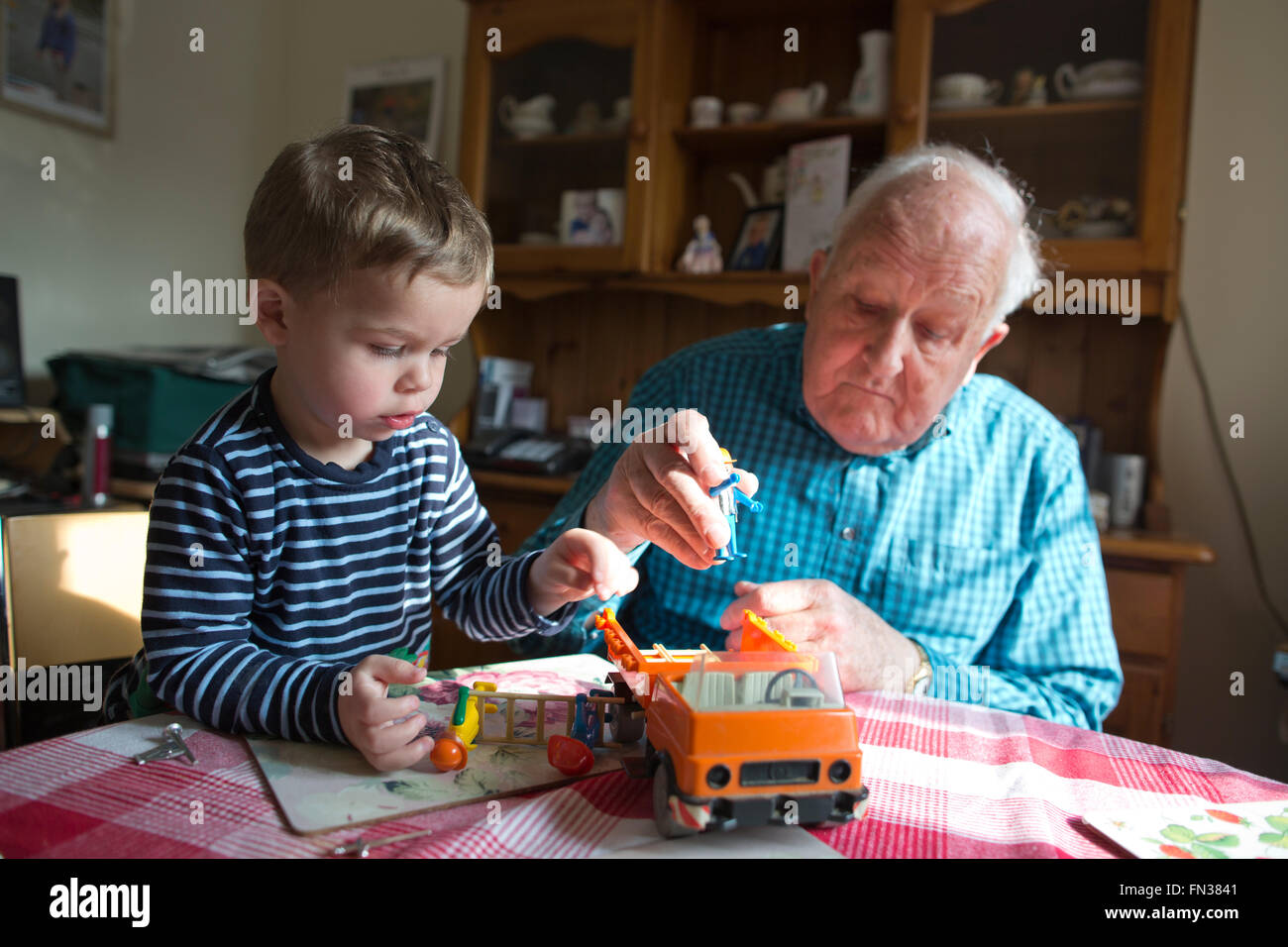 Nonno (84 anni) giocando con il suo nipote (2 anni) a casa nel Dorset, Southwest England, Regno Unito Foto Stock
