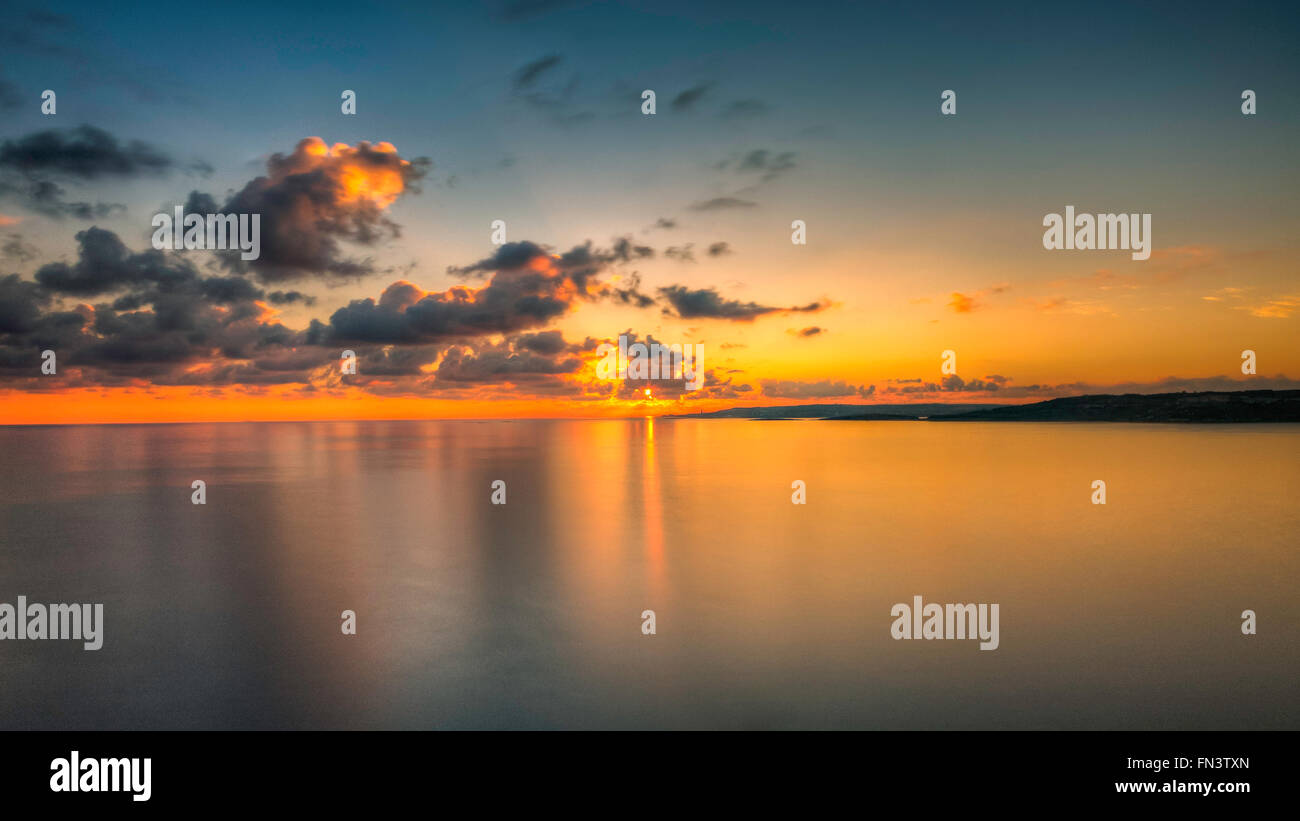 Bellissimo Mare, nuvole, Terra e Sunrise. Malta, l'Europa. Esposizione lunga Foto Stock