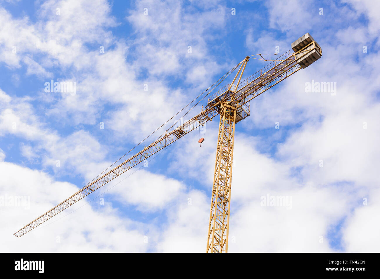 Giallo gru industriali lavorando sul sito di costruzione contro il cielo blu Foto Stock