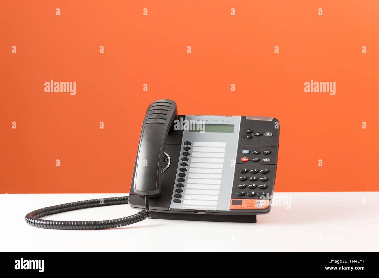 Telefono ufficio su uno sfondo arancione. Foto Stock