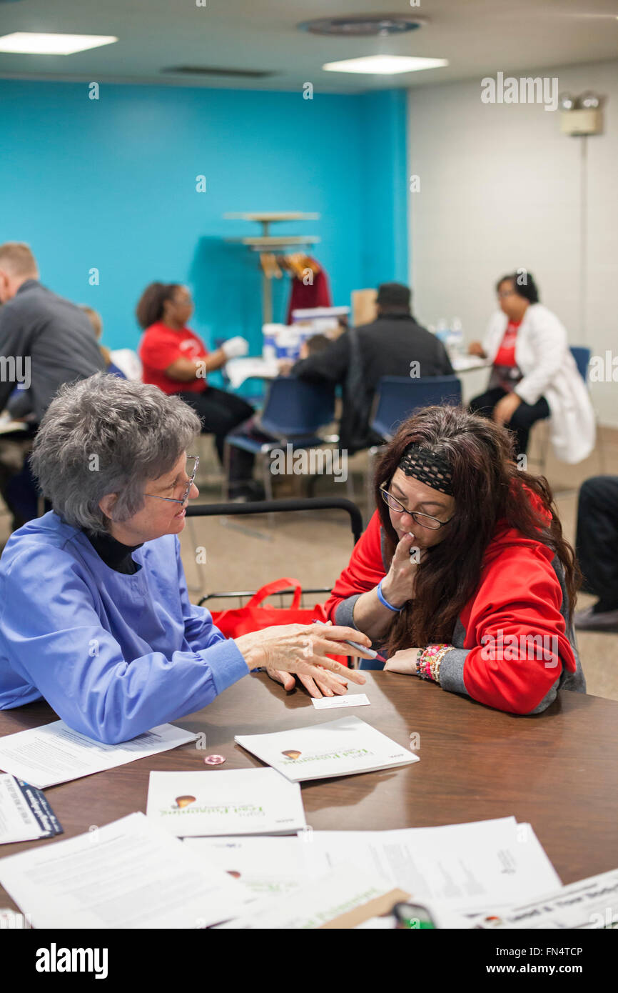 Selce, Michigan - Janet Barnfather (sinistra) spiega i risultati di un esame del sangue per esposizione al piombo a Michele Fiebecker. Foto Stock