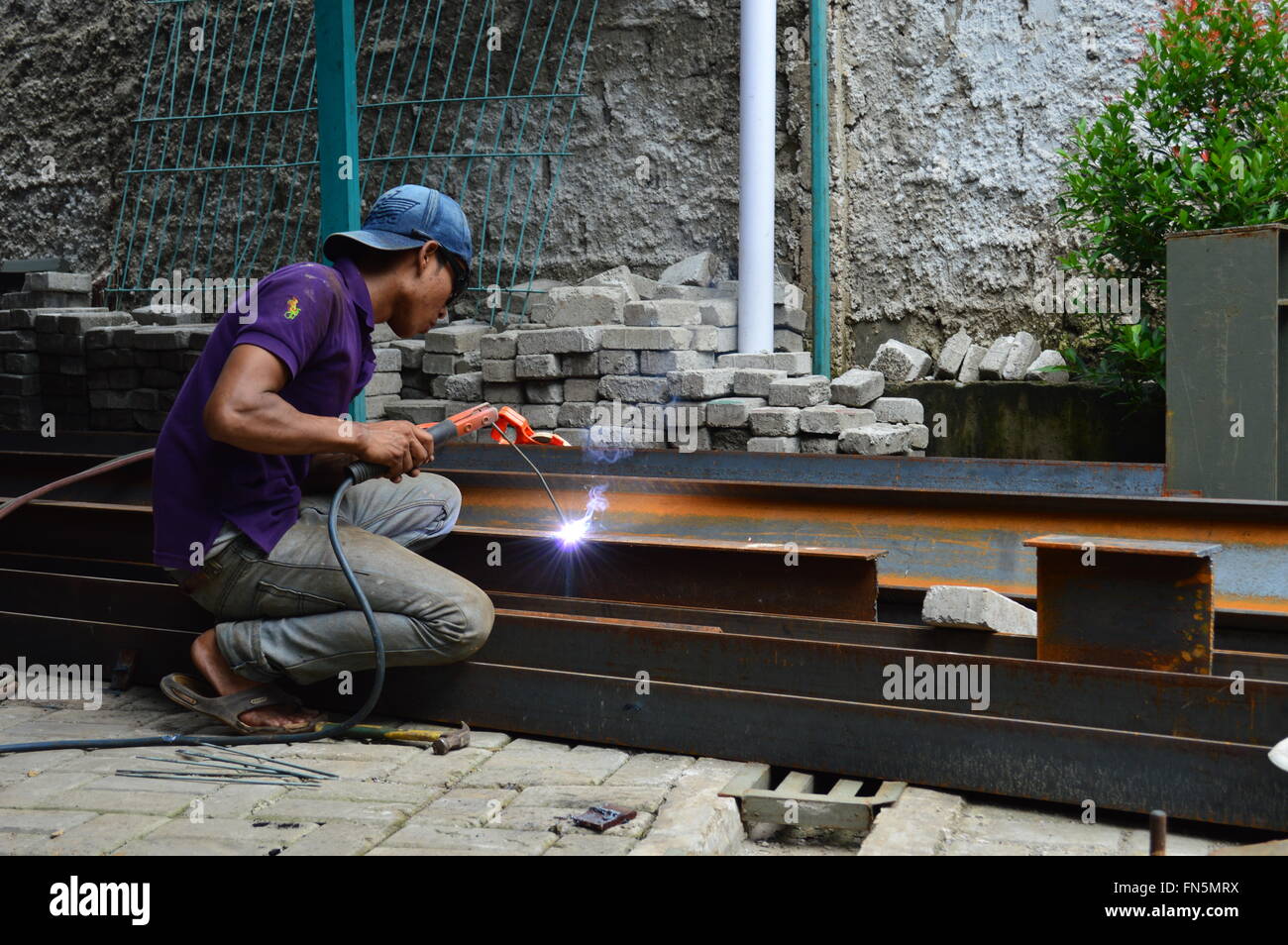 Saldatore o metallurgo facendo lavori di saldatura in un metallo industriale workshop, Jakarta, Indonesia Foto Stock