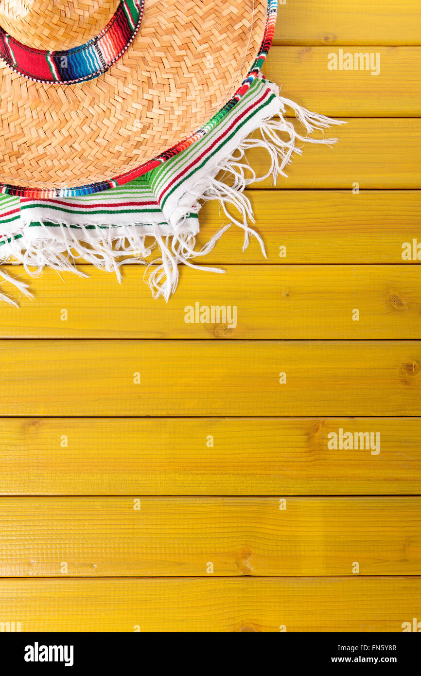 Sombrero messicano e tradizionale coperta serape prevista su un dipinto di giallo in legno di pino piano. Spazio per la copia. Foto Stock